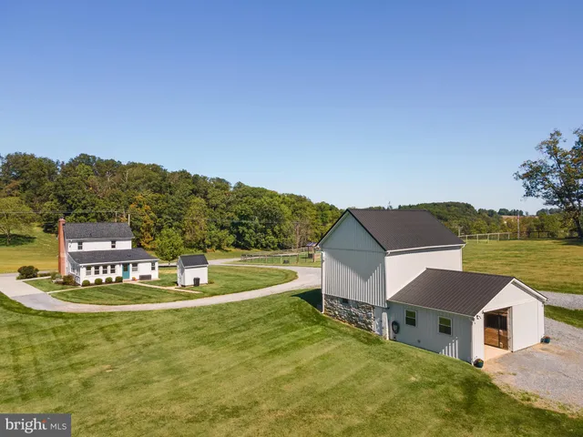 a view of a house with a yard and a large tree