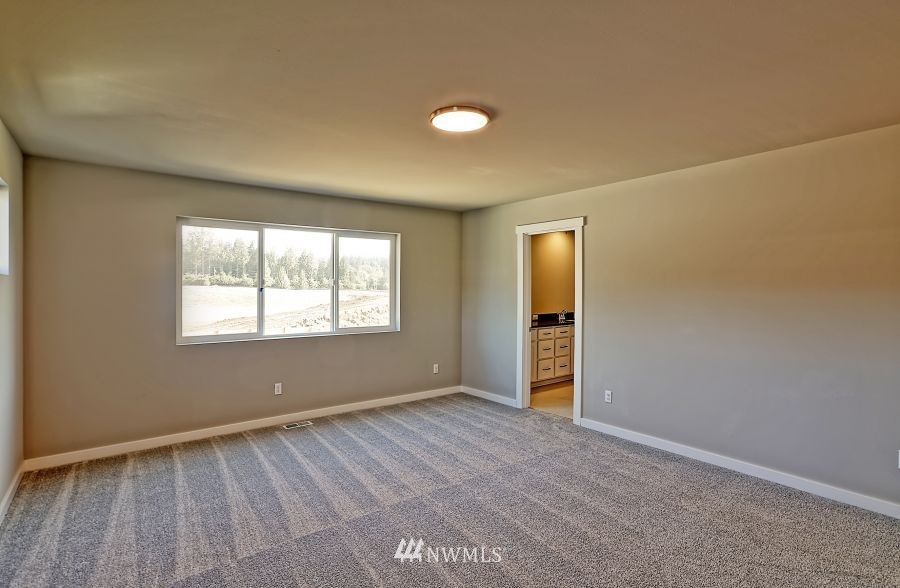 1007 Yew Avenue Sultan, WA 98294 - Photo 11 of 18 an empty room with wooden floor and windows