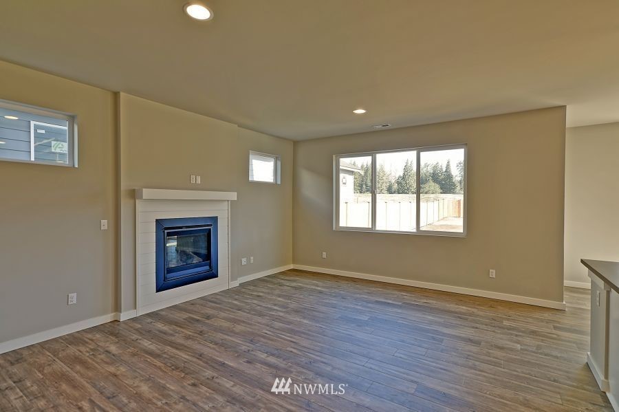 1007 Yew Avenue Sultan, WA 98294 - Photo 12 of 18 a view of empty room with wooden floor and fireplace