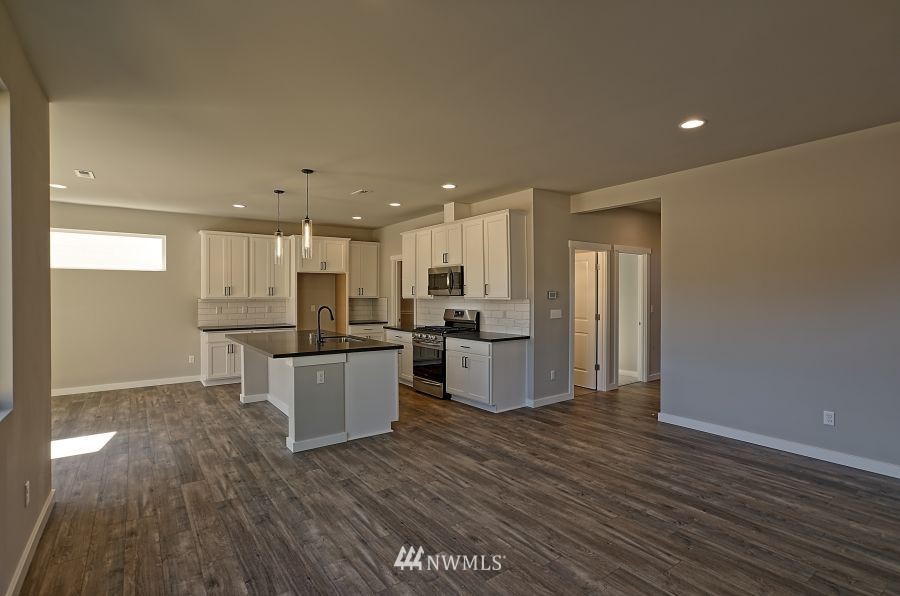 1007 Yew Avenue Sultan, WA 98294 - Photo 13 of 18 a kitchen with a refrigerator and a wooden floor