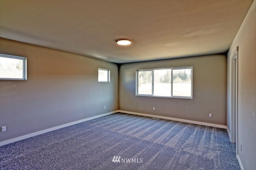 1007 Yew Avenue Sultan, WA 98294 - Photo 15 of 18 a view of an empty room with wooden floor and a window