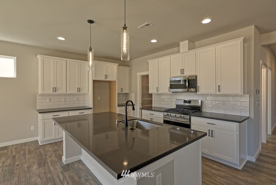 1007 Yew Avenue Sultan, WA 98294 - Photo 9 of 18 a kitchen with stainless steel appliances granite countertop a sink a stove and a refrigerator