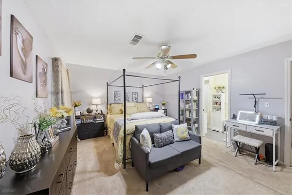 a bedroom with a bed mirror furniture and a flat screen tv
