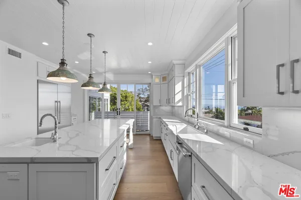 a kitchen with sink and view of living room