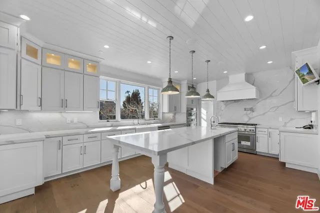 a large kitchen with stainless steel appliances lots of counter space and a sink