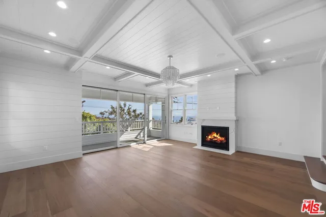 an empty room with windows and fireplace