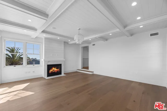an empty room with a fireplace and fan