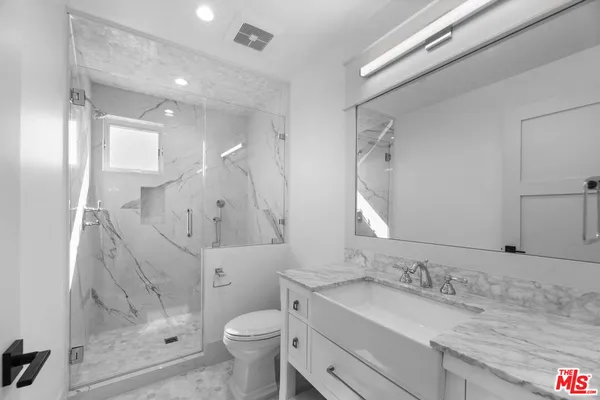 a bathroom with a granite countertop sink toilet and shower