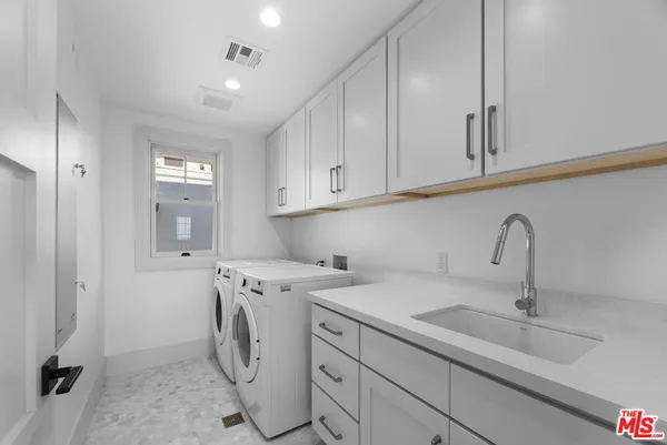 a utility room with cabinets washer and dryer
