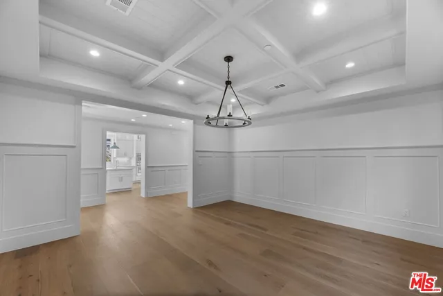 a view of empty room with wooden floor and ceiling fan