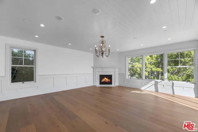a view of an empty room with a fireplace and a window