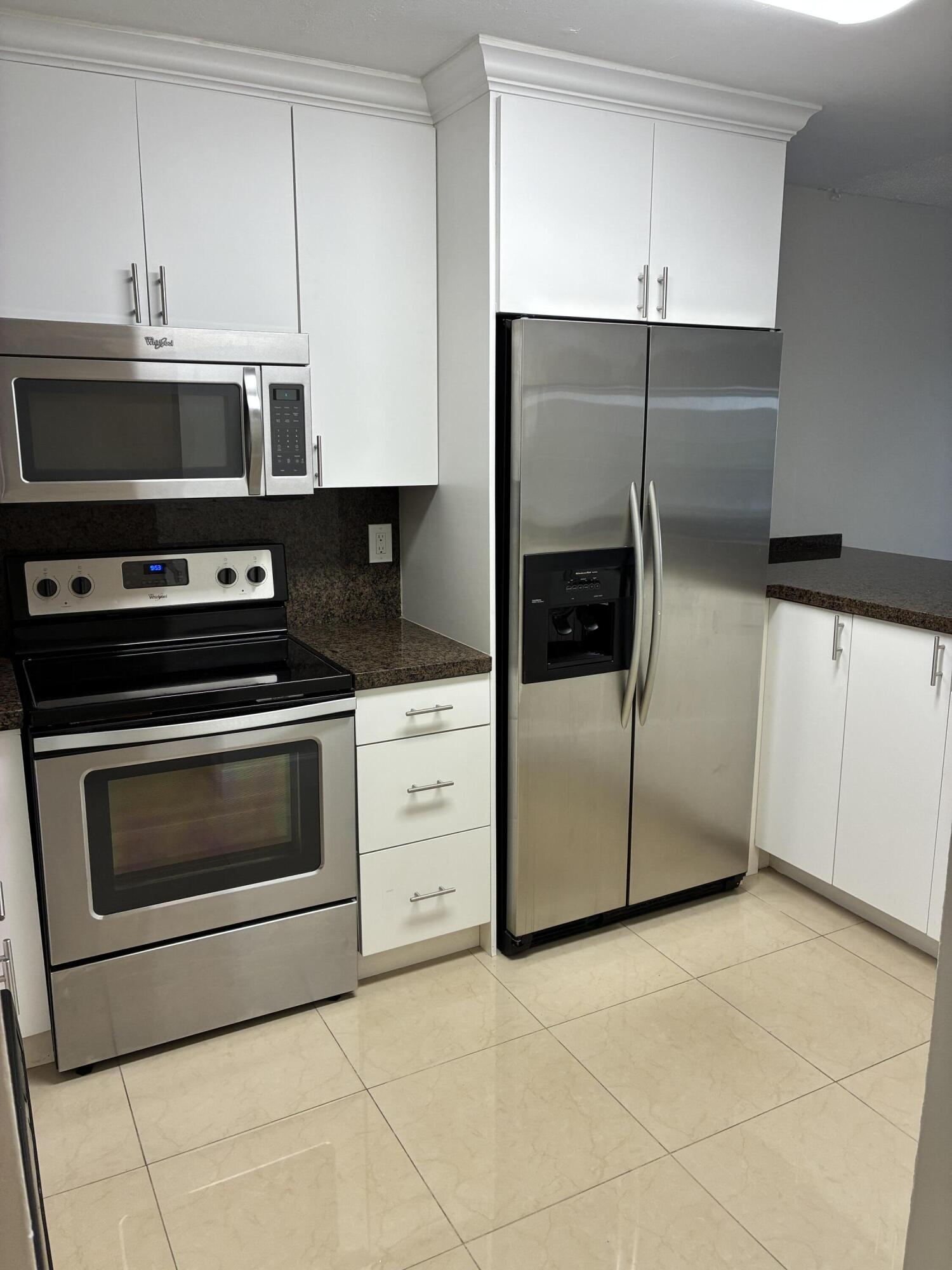 a kitchen with stainless steel appliances a stove a microwave and a refrigerator