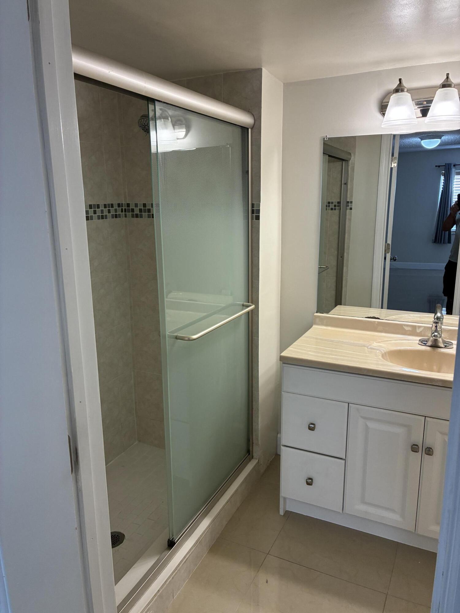 2955 Riverside Drive, Unit 103 Coral Springs, FL 33065 - Photo 17 of 26 a bathroom with a shower sink and mirror