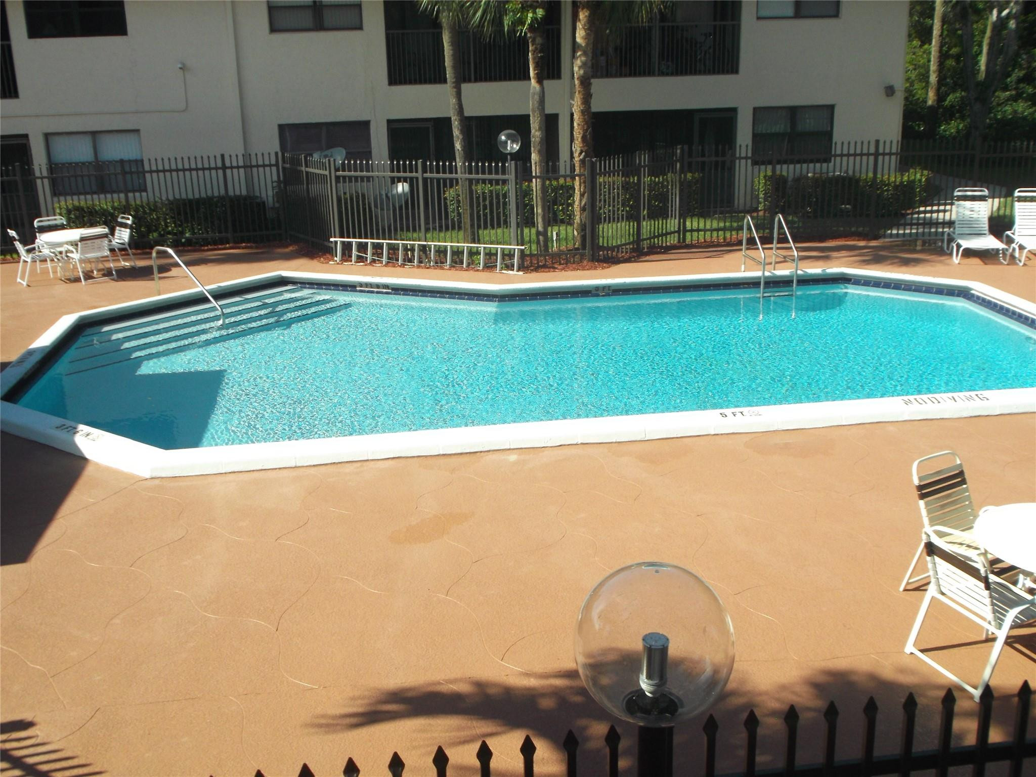 2955 Riverside Drive, Unit 103 Coral Springs, FL 33065 - Photo 24 of 26 a swimming pool with outdoor seating and yard