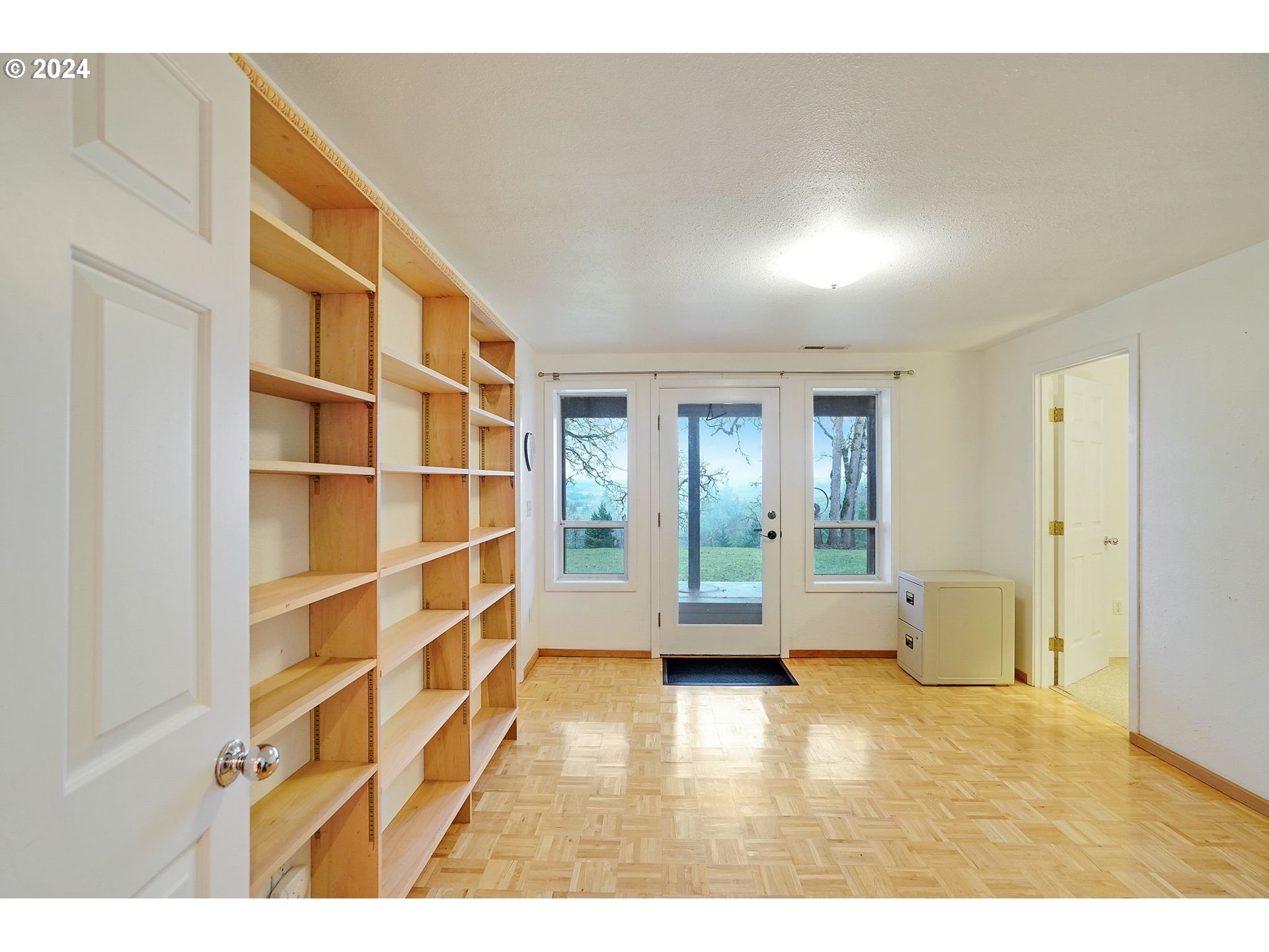 2080 Cherry Knoll Road Dallas, OR 97338 - Photo 27 of 48 a view of an empty room with wooden floor and cabinets