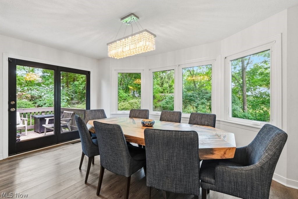 2323 Call Road Stow, OH 44224 - Photo 21 of 42 Dining area featuring wood-finish flooring, a rectangular crystal chandelier, and a bay window with multiple panes