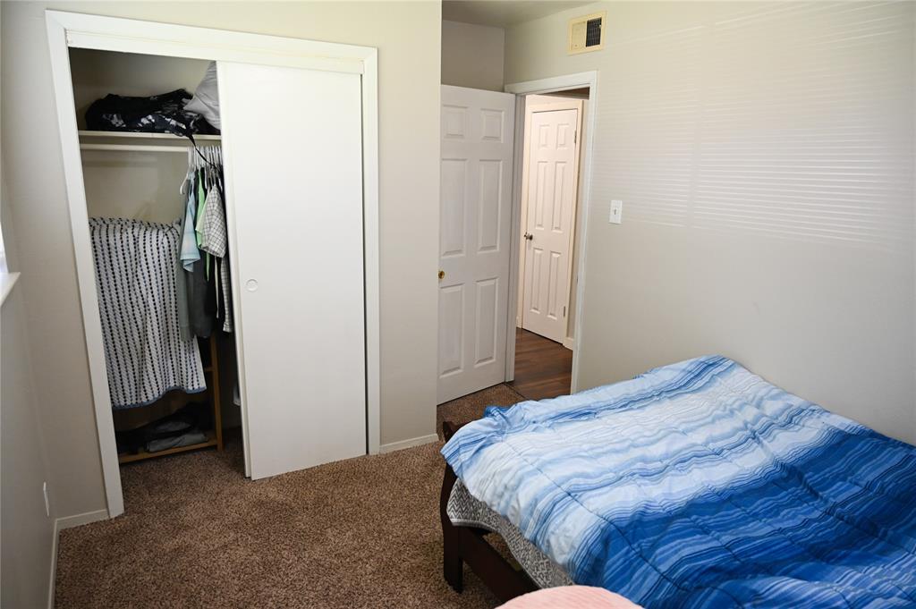 1352 Simpson Drive Hurst, TX 76053 - Photo 8 of 40 Carpeted room featuring a built-in closet with sliding doors, neutral wall paint, and white trim