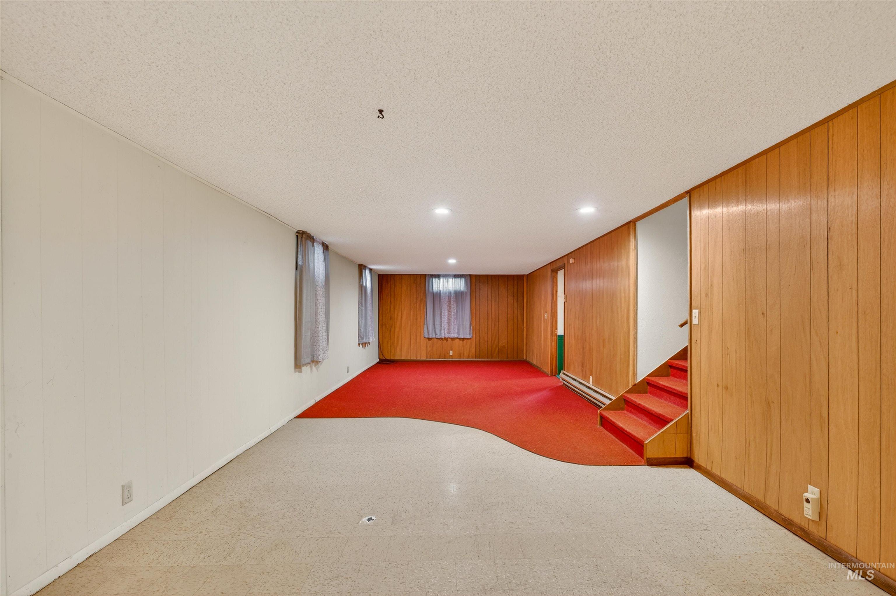 609 Grelle Avenue Lewiston, ID 83501 - Photo 27 of 48 Finished below grade area featuring wooden walls, recessed lighting, a textured ceiling, a baseboard radiator, and carpet flooring