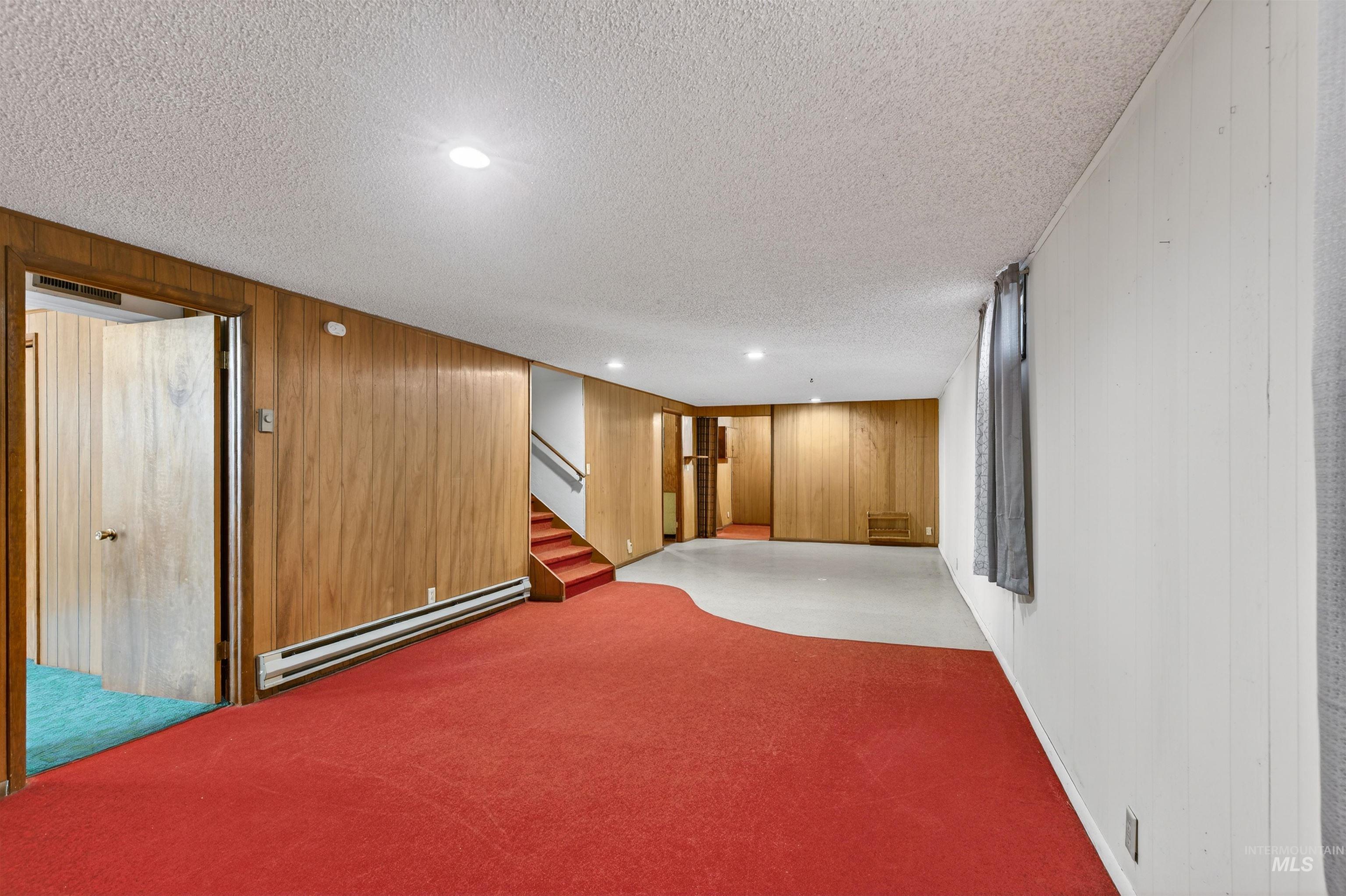 609 Grelle Avenue Lewiston, ID 83501 - Photo 28 of 48 Finished below grade area featuring wooden walls, a baseboard radiator, recessed lighting, carpet flooring, and a textured ceiling