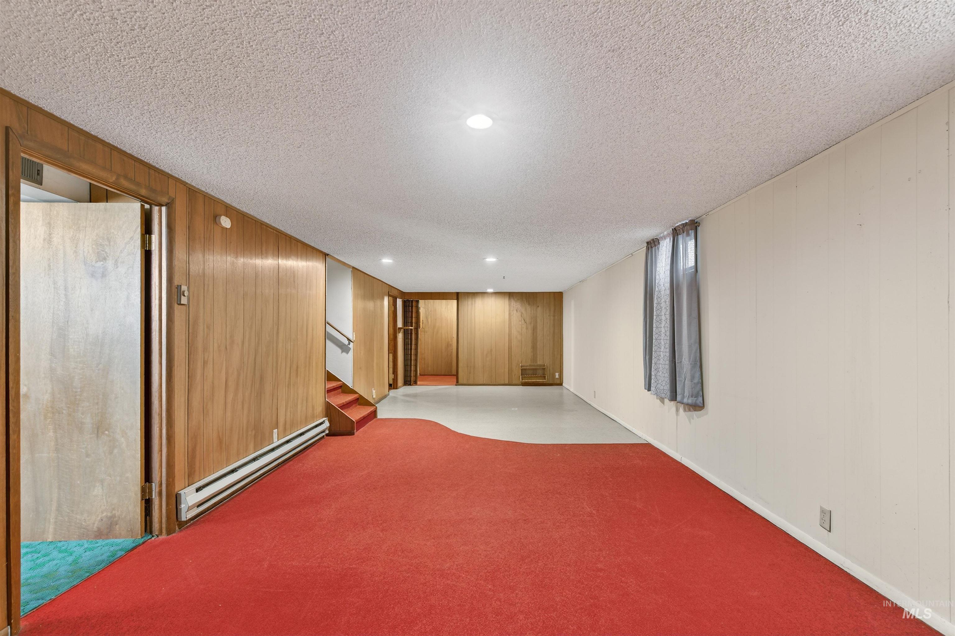 609 Grelle Avenue Lewiston, ID 83501 - Photo 29 of 48 Finished below grade area with baseboard heating, wooden walls, a textured ceiling, light carpet, and recessed lighting