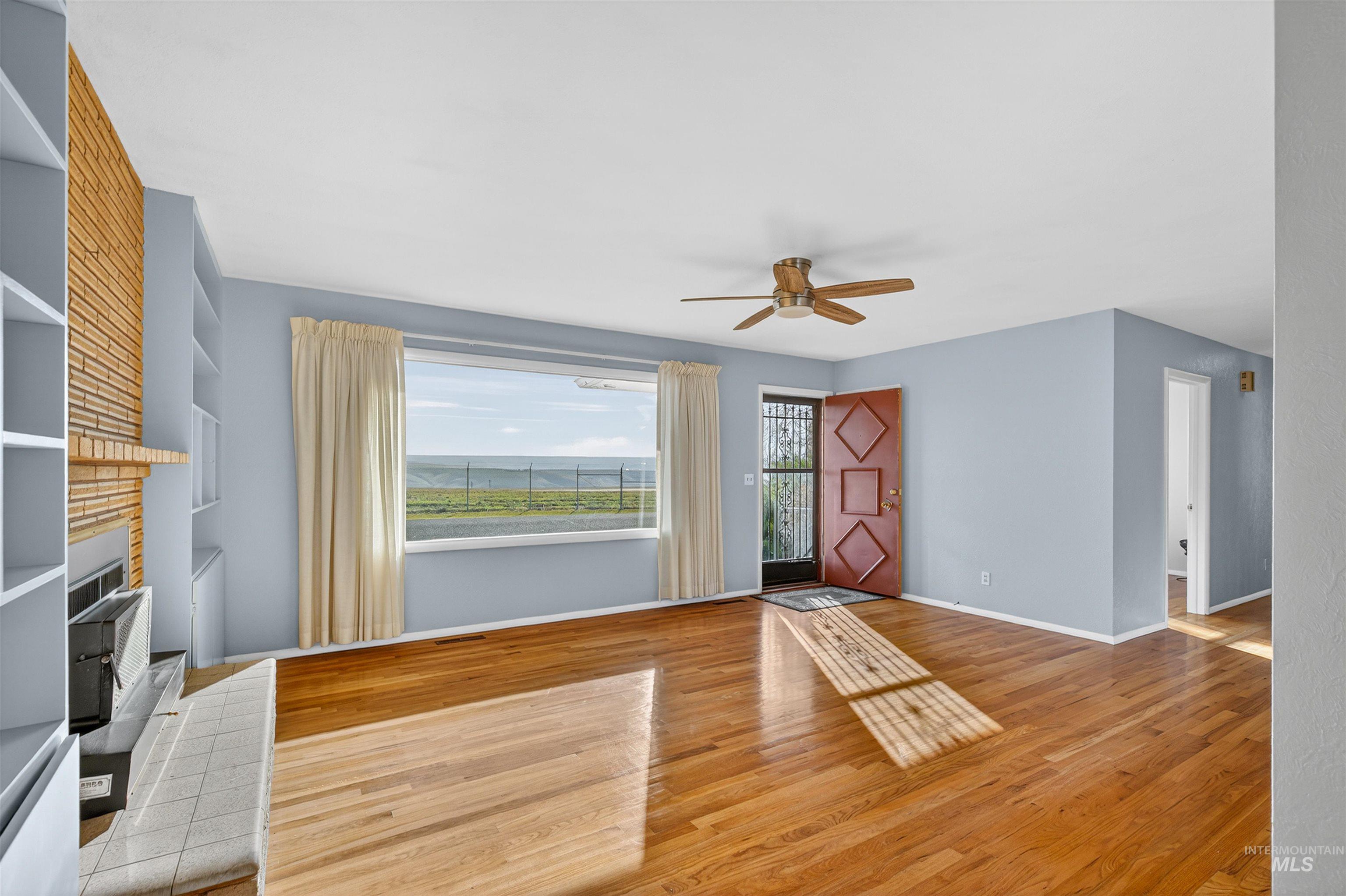 609 Grelle Avenue Lewiston, ID 83501 - Photo 7 of 48 Unfurnished living room with ceiling fan, light wood-type flooring, and a water view