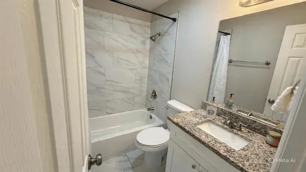 a bathroom with a granite countertop sink toilet and shower