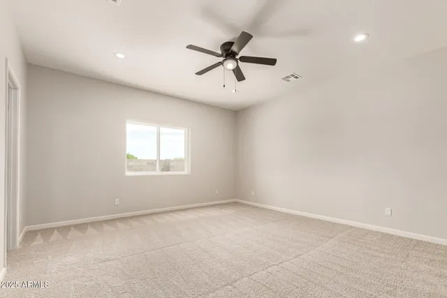 an empty room with a window and a fan