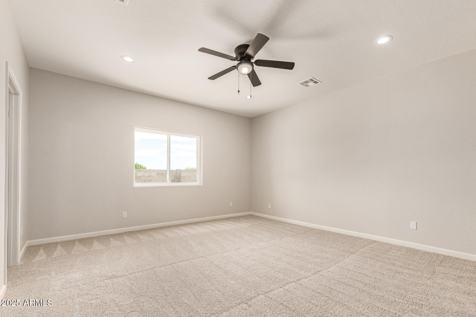 15941 South Animas Road Arizona City, AZ 85123 - Photo 12 of 26 an empty room with a window and a fan