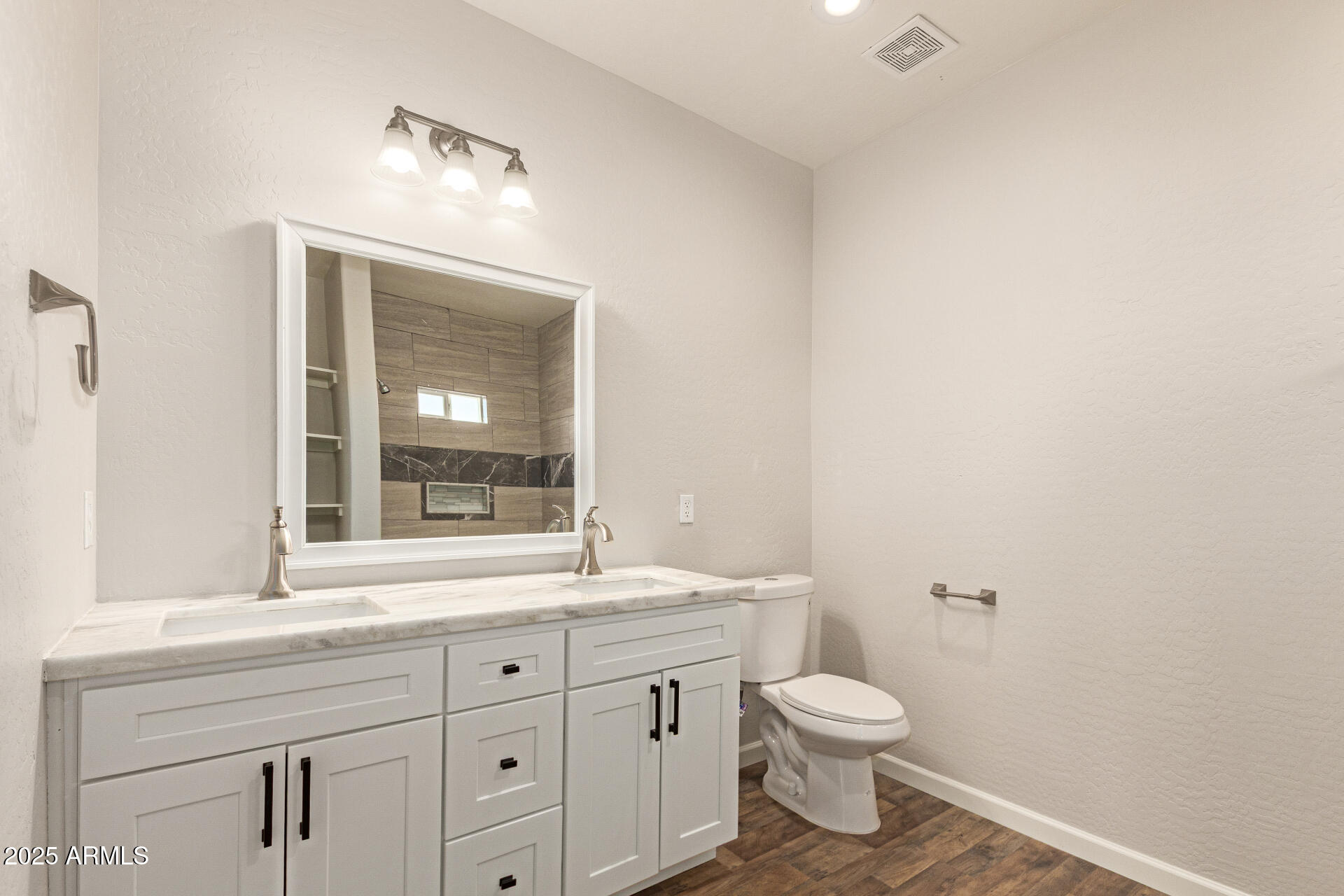 15941 South Animas Road Arizona City, AZ 85123 - Photo 14 of 26 a bathroom with a granite countertop toilet a sink a mirror and a window