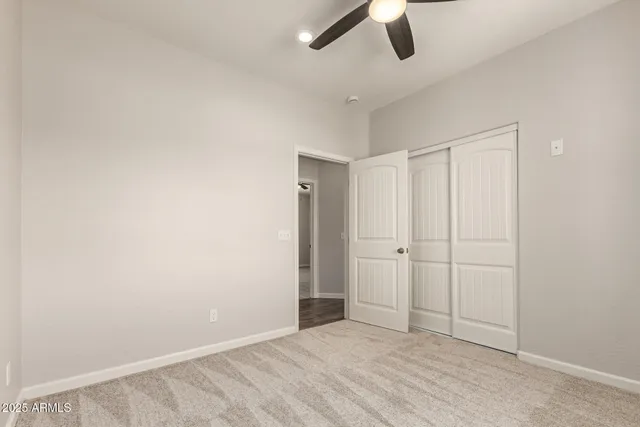 an empty room with ceiling fan and window