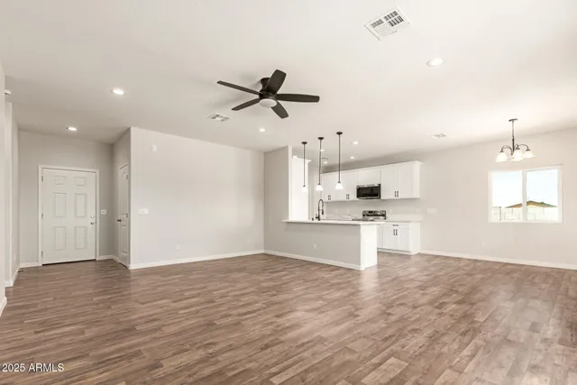 a view of kitchen with stainless steel appliances kitchen island in the center and wooden floor