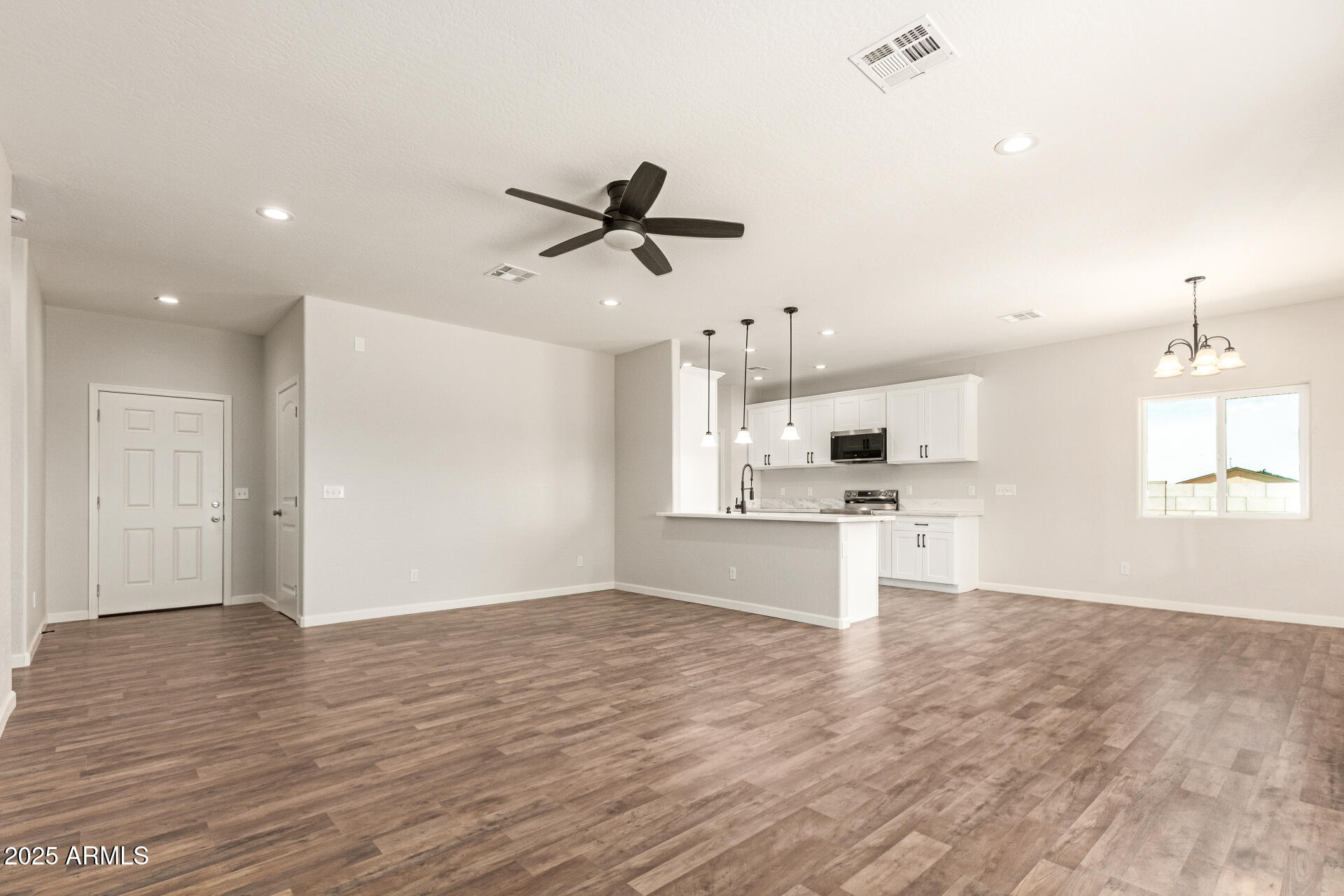15941 South Animas Road Arizona City, AZ 85123 - Photo 5 of 26 a view of kitchen with stainless steel appliances kitchen island in the center and wooden floor