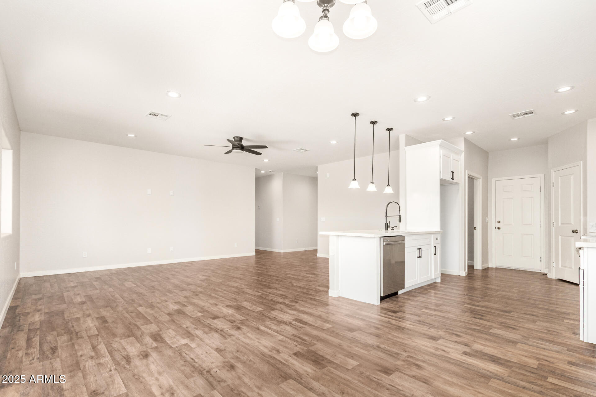 15941 South Animas Road Arizona City, AZ 85123 - Photo 7 of 26 a view of empty room with wooden floor and kitchen