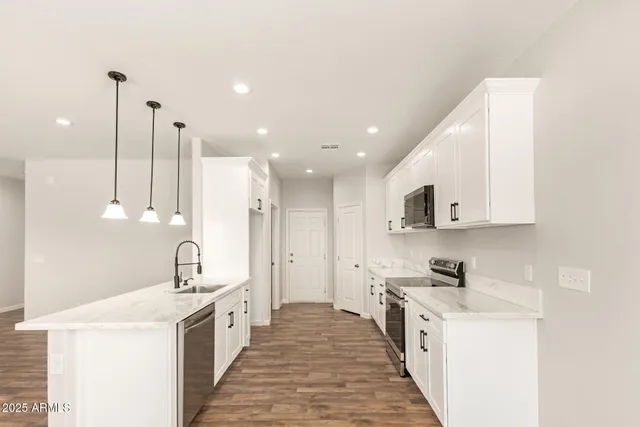a large kitchen with stainless steel appliances sink a stove and a refrigerator