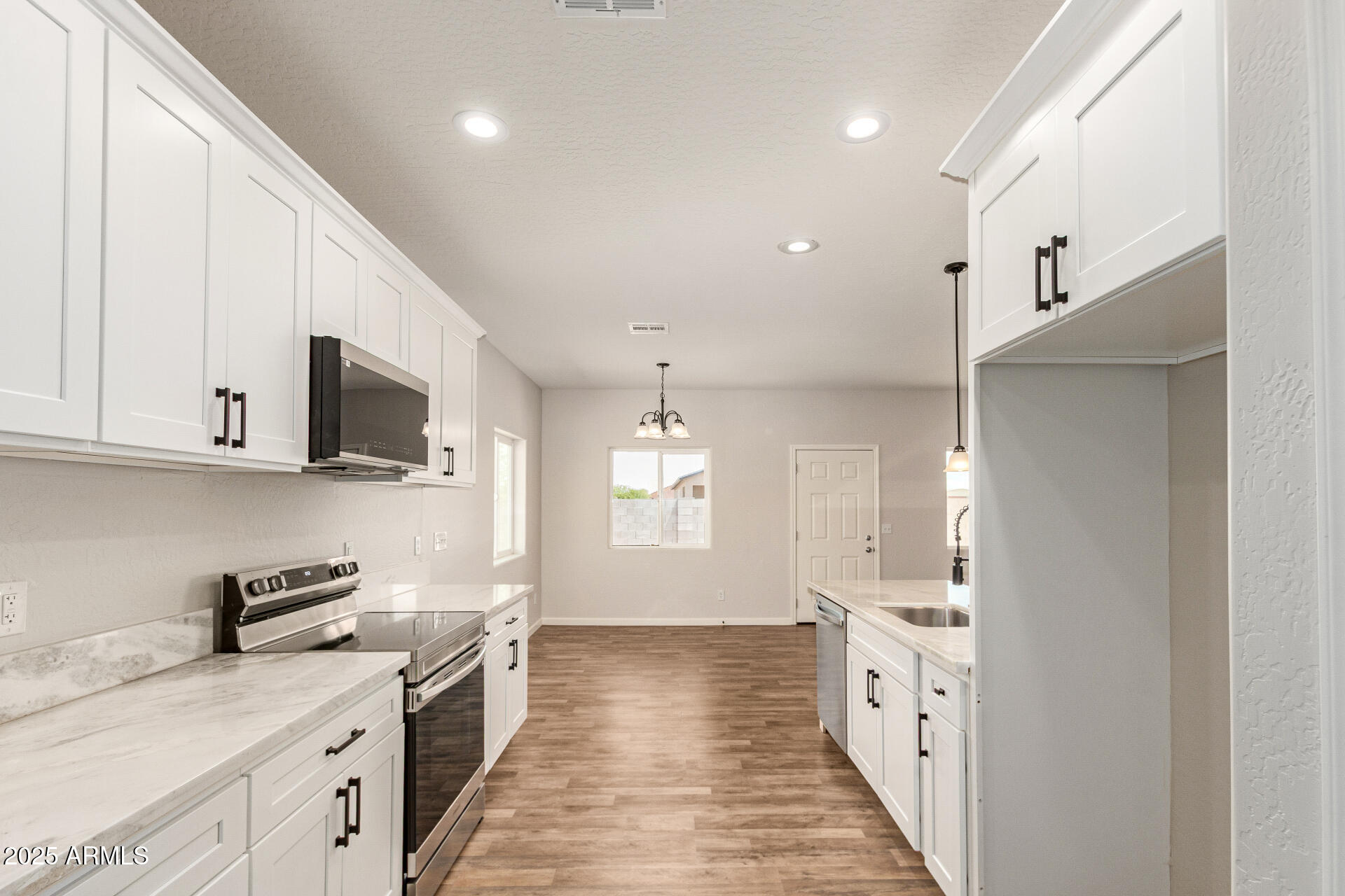 15941 South Animas Road Arizona City, AZ 85123 - Photo 10 of 26 a large kitchen with stainless steel appliances granite countertop a lot of counter space and wooden floor