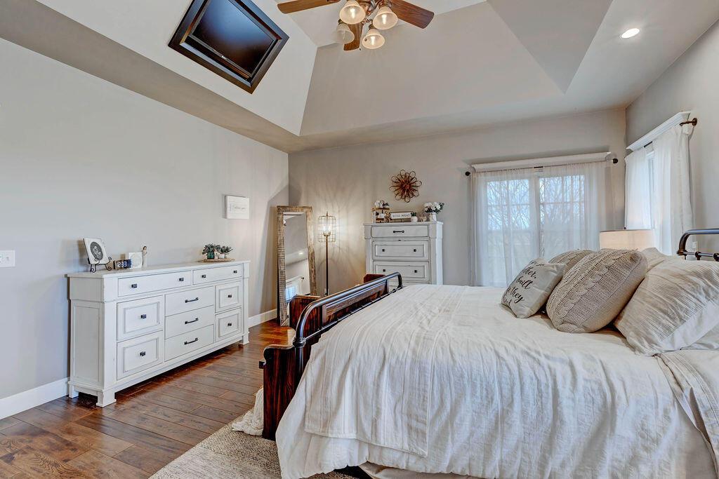 4045 Russell Road Mount Gilead, OH 43338 - Photo 25 of 74 • Handscraped hardwood flooring • Gray painted walls •Four-light ceiling fan • TV framed in ceiling above bed (angle) • Lots of light/windows
