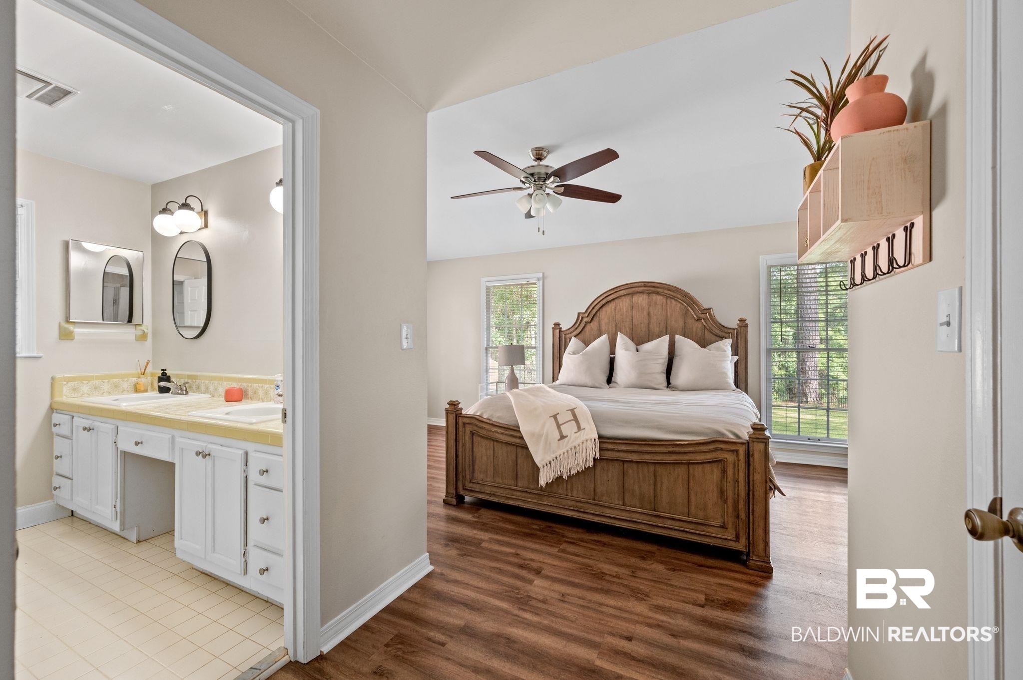 110 Ferncliff Circle Daphne, AL 36526 - Photo 22 of 40 Bedroom featuring a sink, connected bathroom, baseboards, and light wood-type flooring
