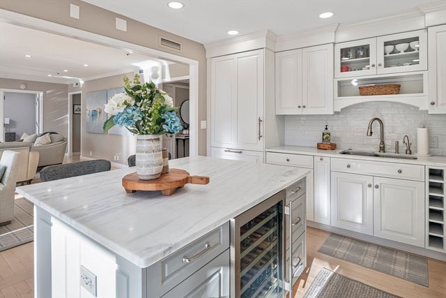 a kitchen with kitchen island granite countertop a sink cabinets and stainless steel appliances