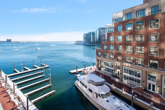 a living room with furniture a flat screen tv and kitchen view