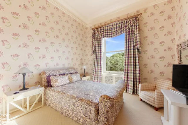 a bedroom with a bed couch and a window