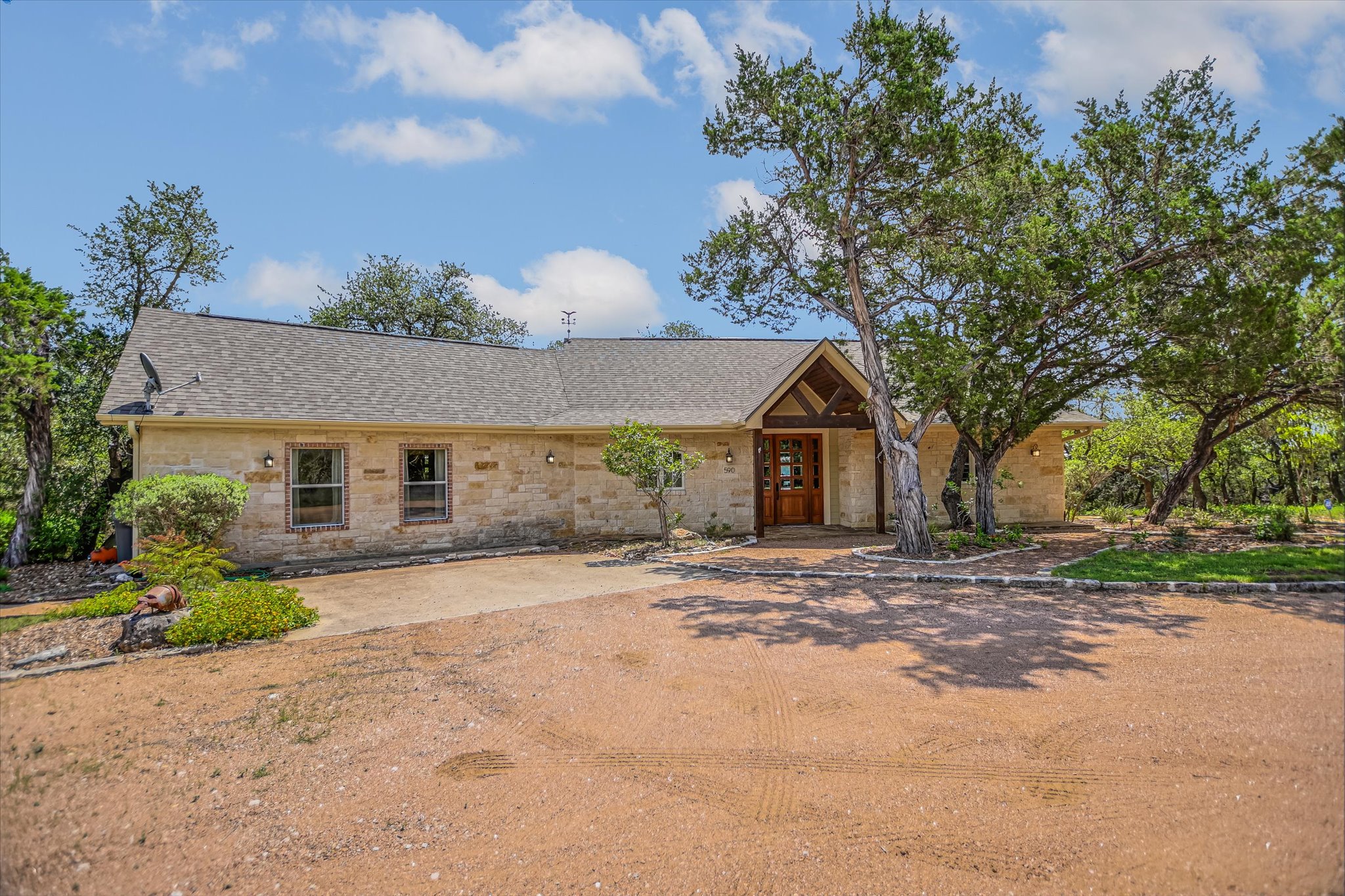 590 Rancho Grande Drive Wimberley, TX 78676 - Photo 29 of 30 a front view of a house with a yard and garage