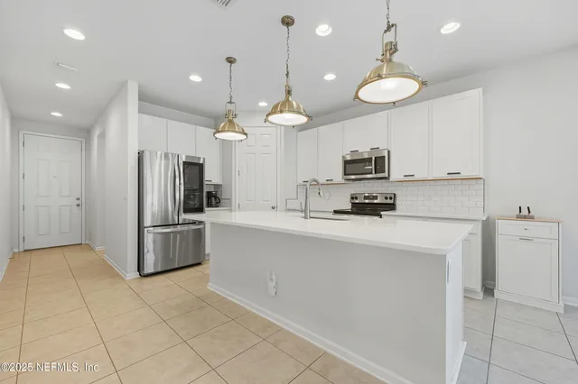 a kitchen with stainless steel appliances a refrigerator sink and microwave