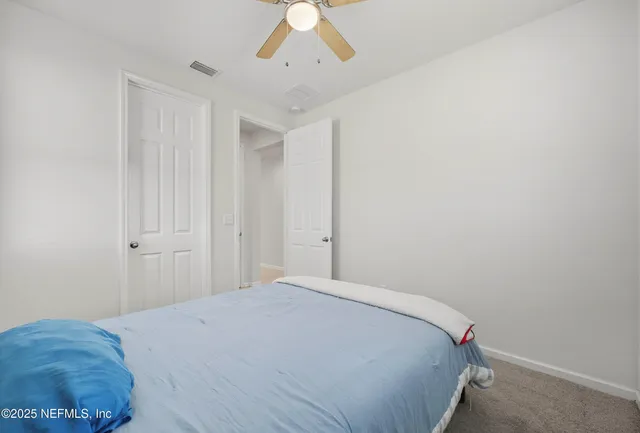 a bedroom with a bed and a chandelier fan