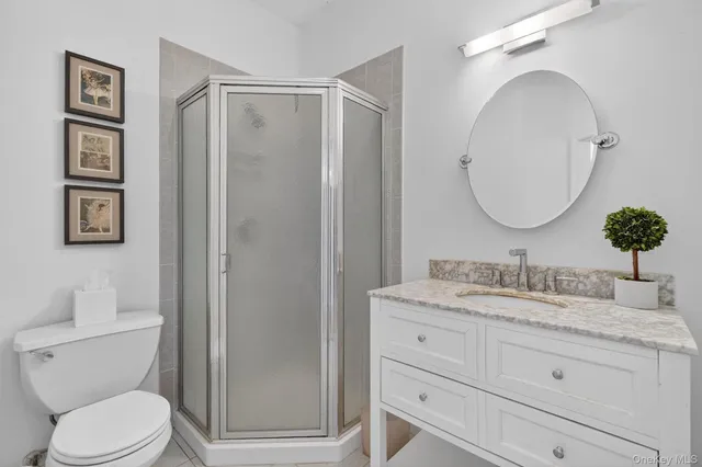 a bathroom with a granite countertop toilet sink and mirror