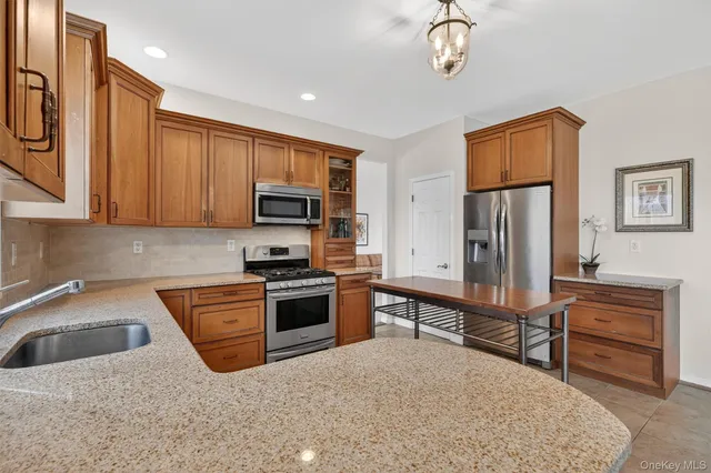 a kitchen with stainless steel appliances granite countertop a refrigerator a stove top oven a sink and dishwasher