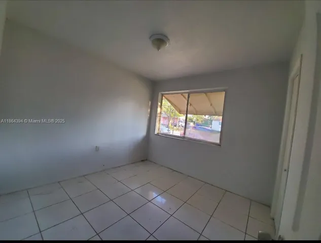 a view of a white house with a tree and a yard