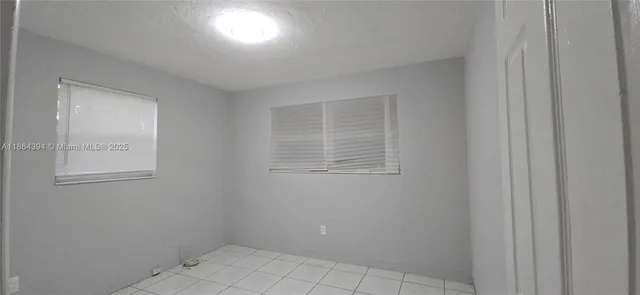 a view of a backyard with plants and large trees