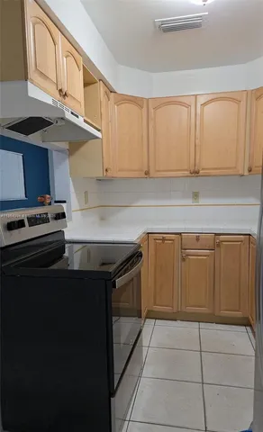 a view of a backyard with plants and large trees