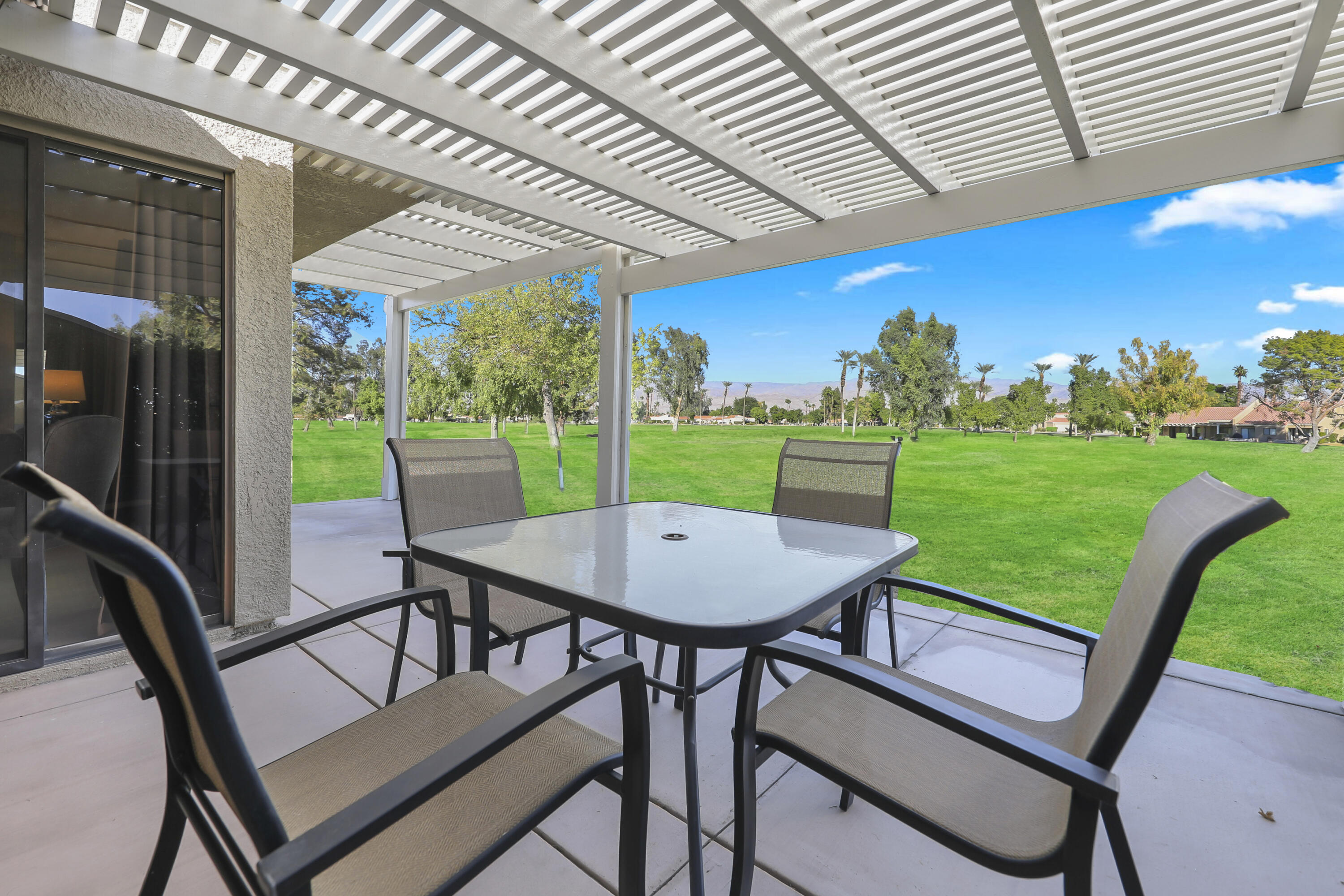 41476 Inverness Way Palm Desert, CA 92211 - Photo 18 of 37 a view of a patio with a table chairs and a backyard