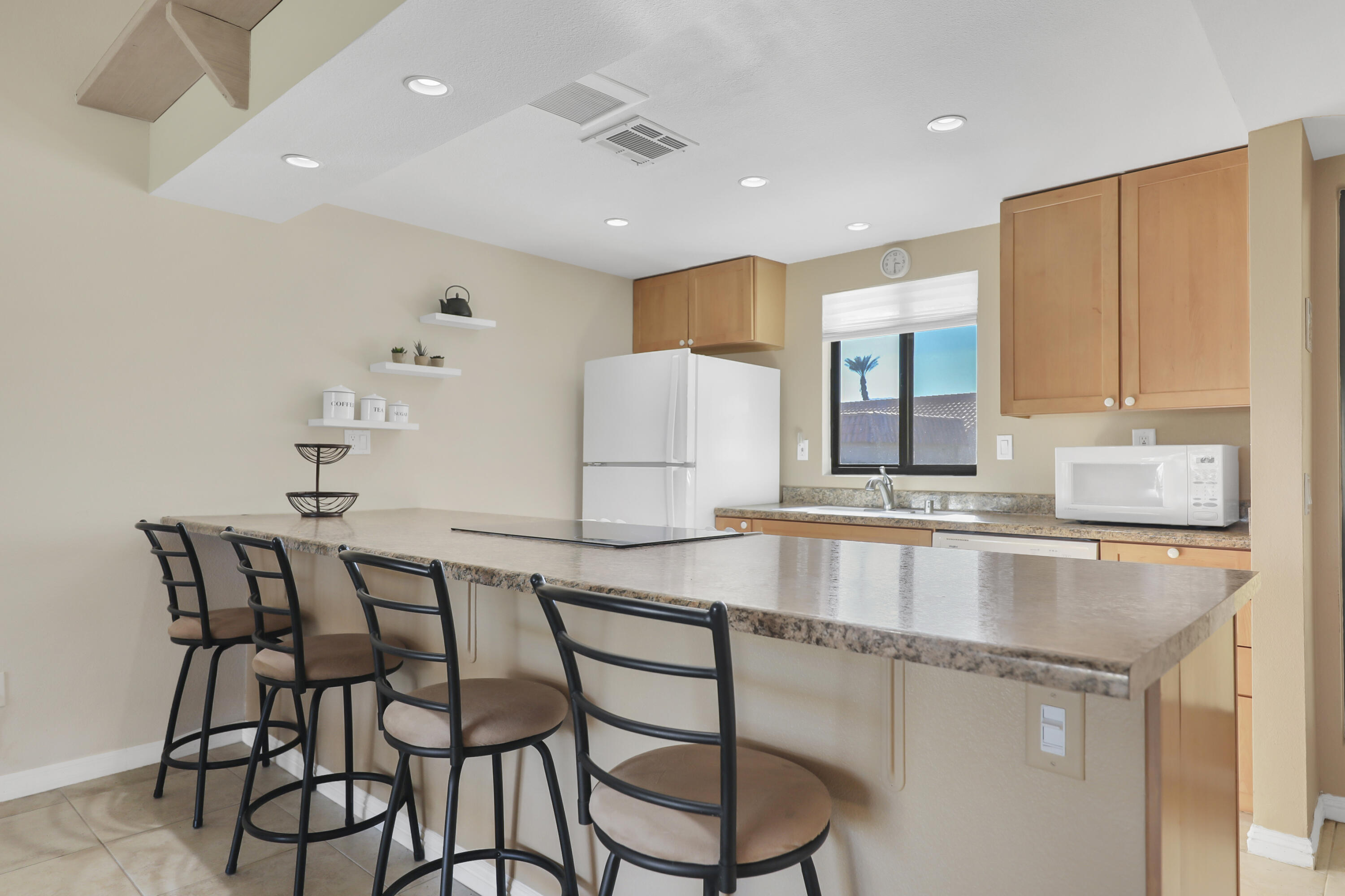 41476 Inverness Way Palm Desert, CA 92211 - Photo 3 of 37 a kitchen with granite countertop cabinets and chairs